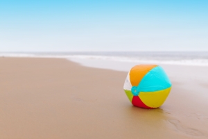 Ein bunter Ball liegt am Strand.