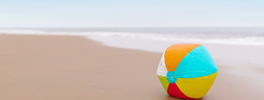 Ein bunter Ball liegt am Strand.